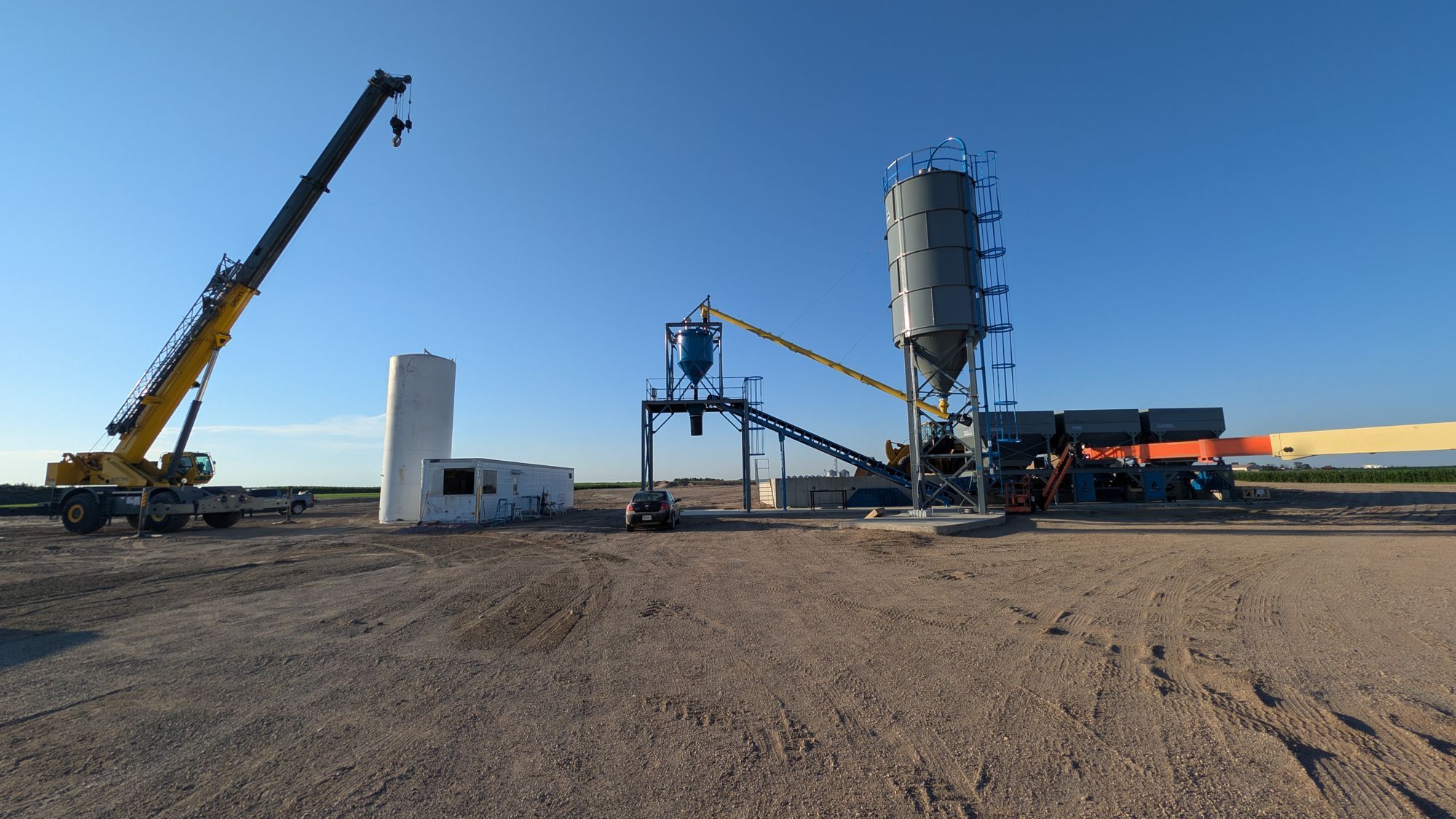 Wide view of the Rayvon Redimix batch plant, with silos and a crane.