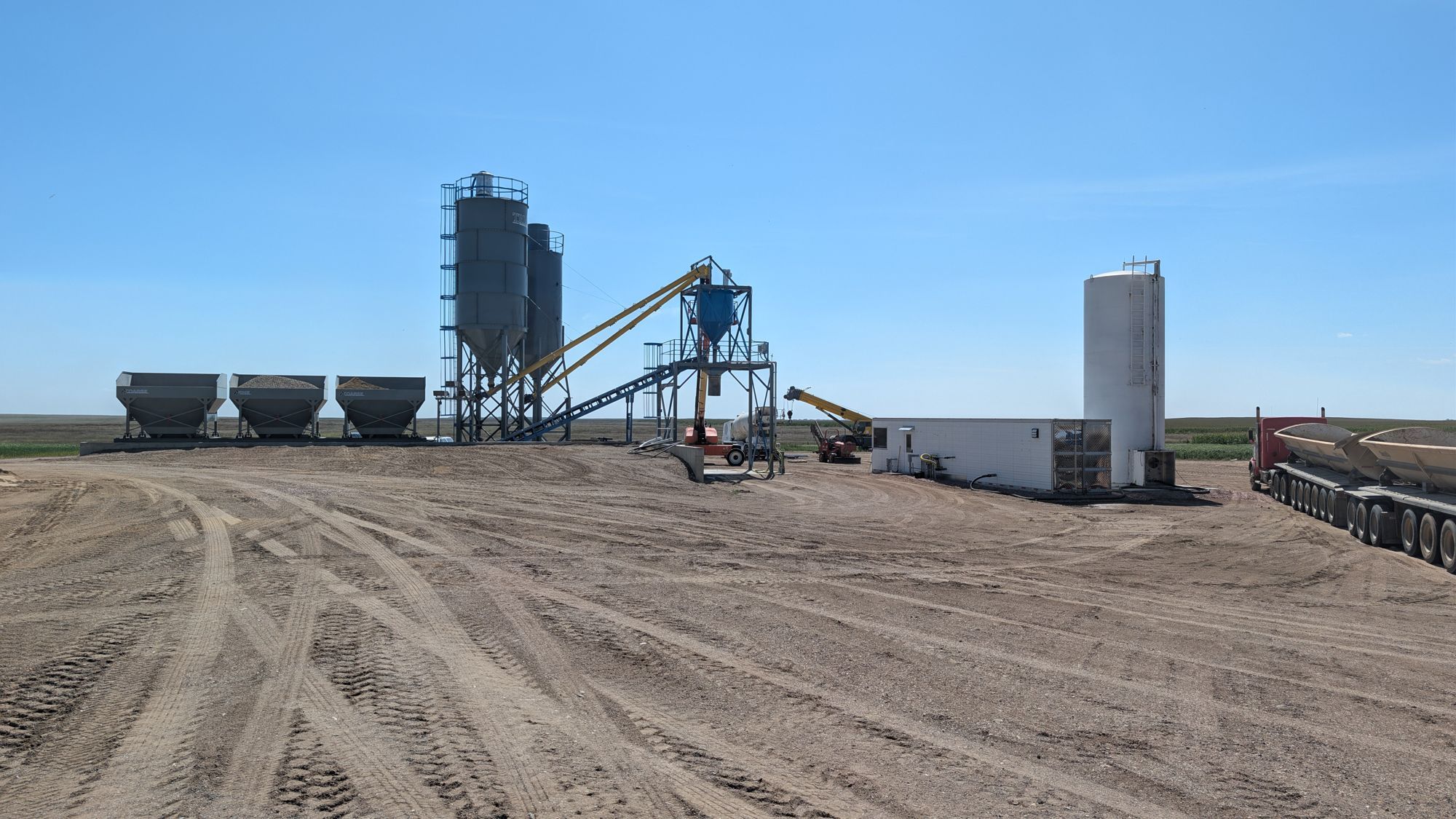 Batch plant with hoppers and silos along the yard.