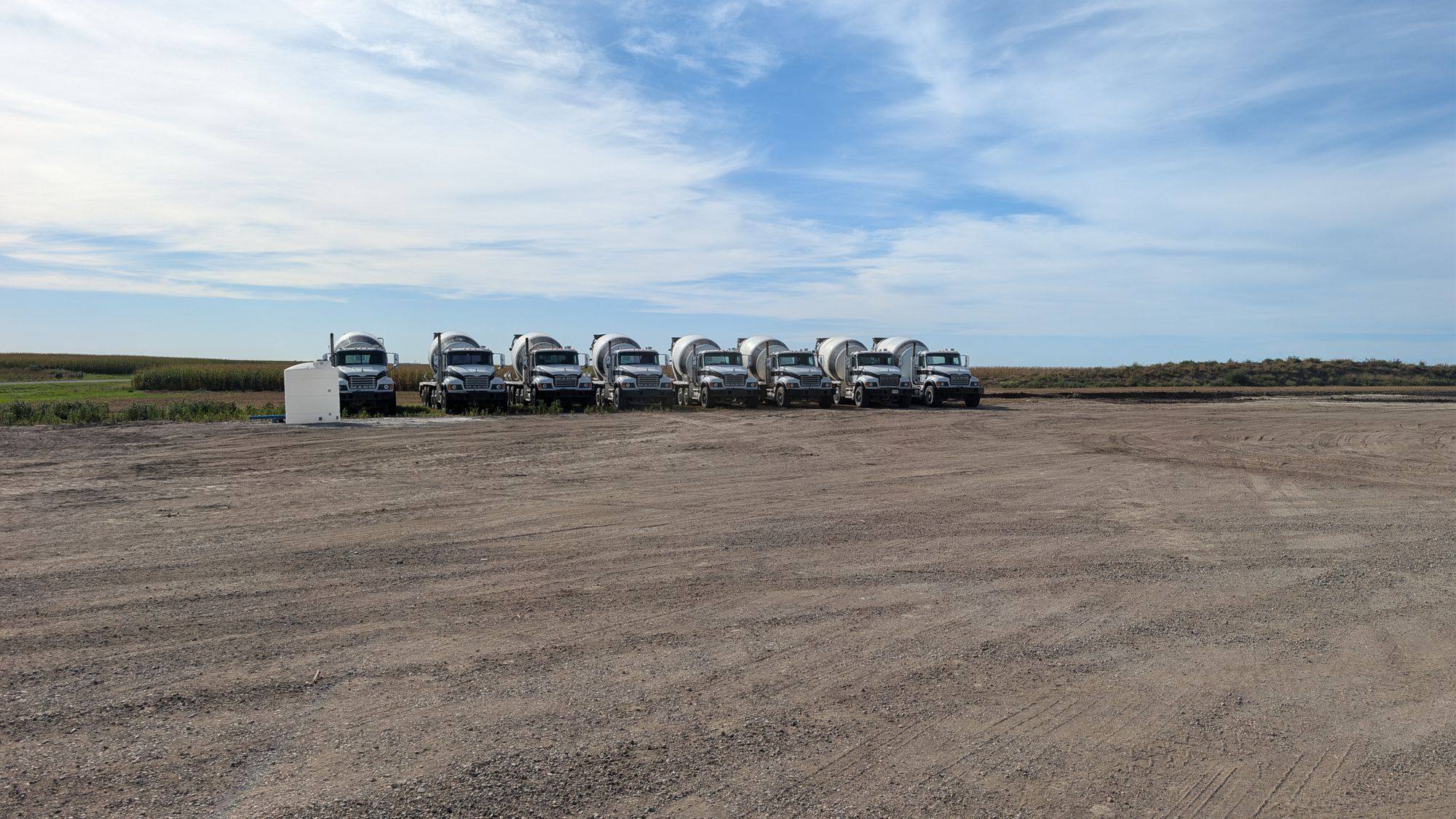 Mixer trucks lined up facing the camera on the plant yard.